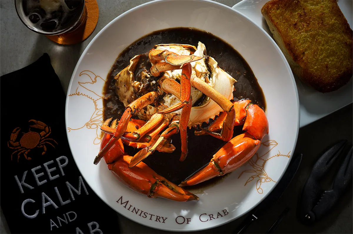 Crab dish with black sauce presentation.
