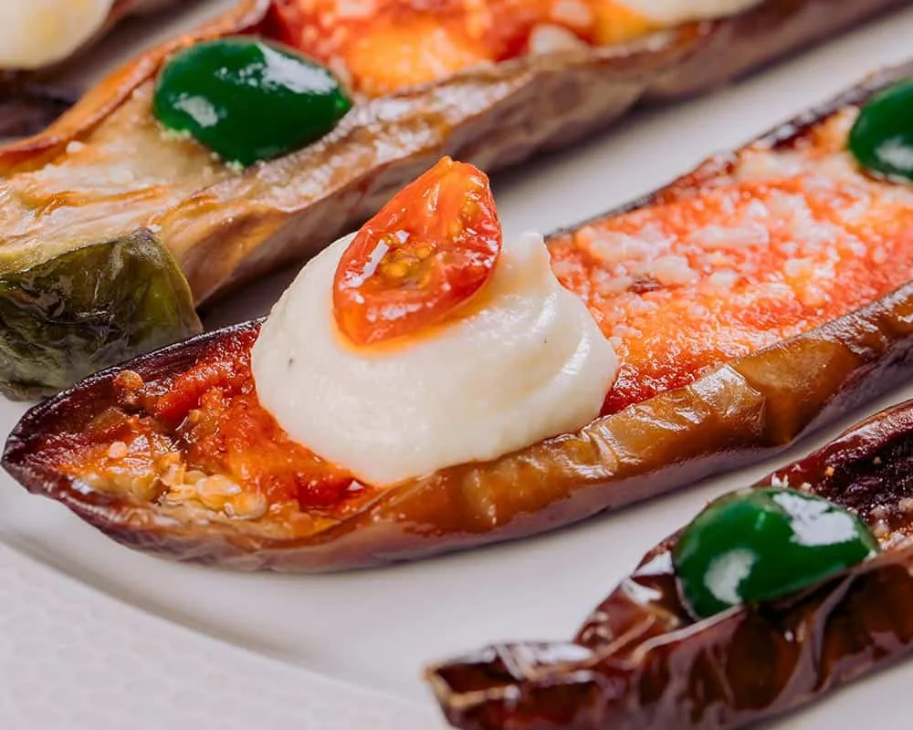 Stuffed aubergines with toppings displayed