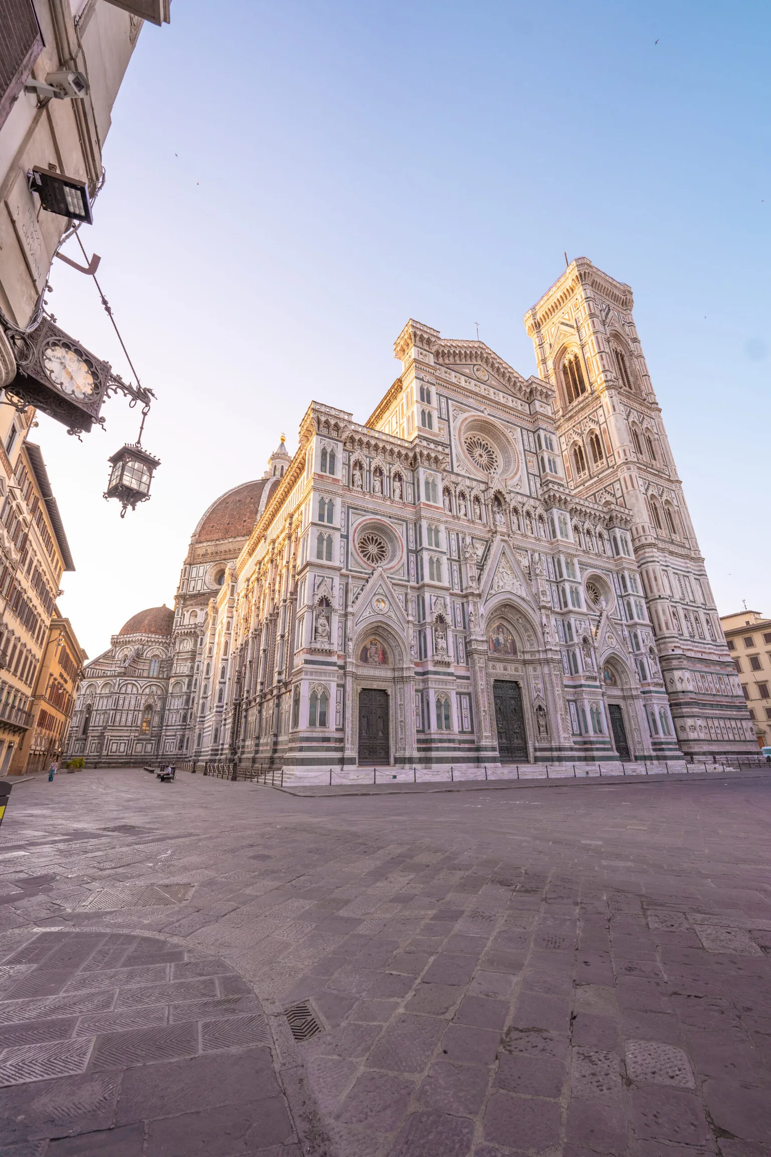 Florence's ornate marble façade of the Cathedral of Santa Maria del Fiore and Giotto's bell tower glowing in morning light.