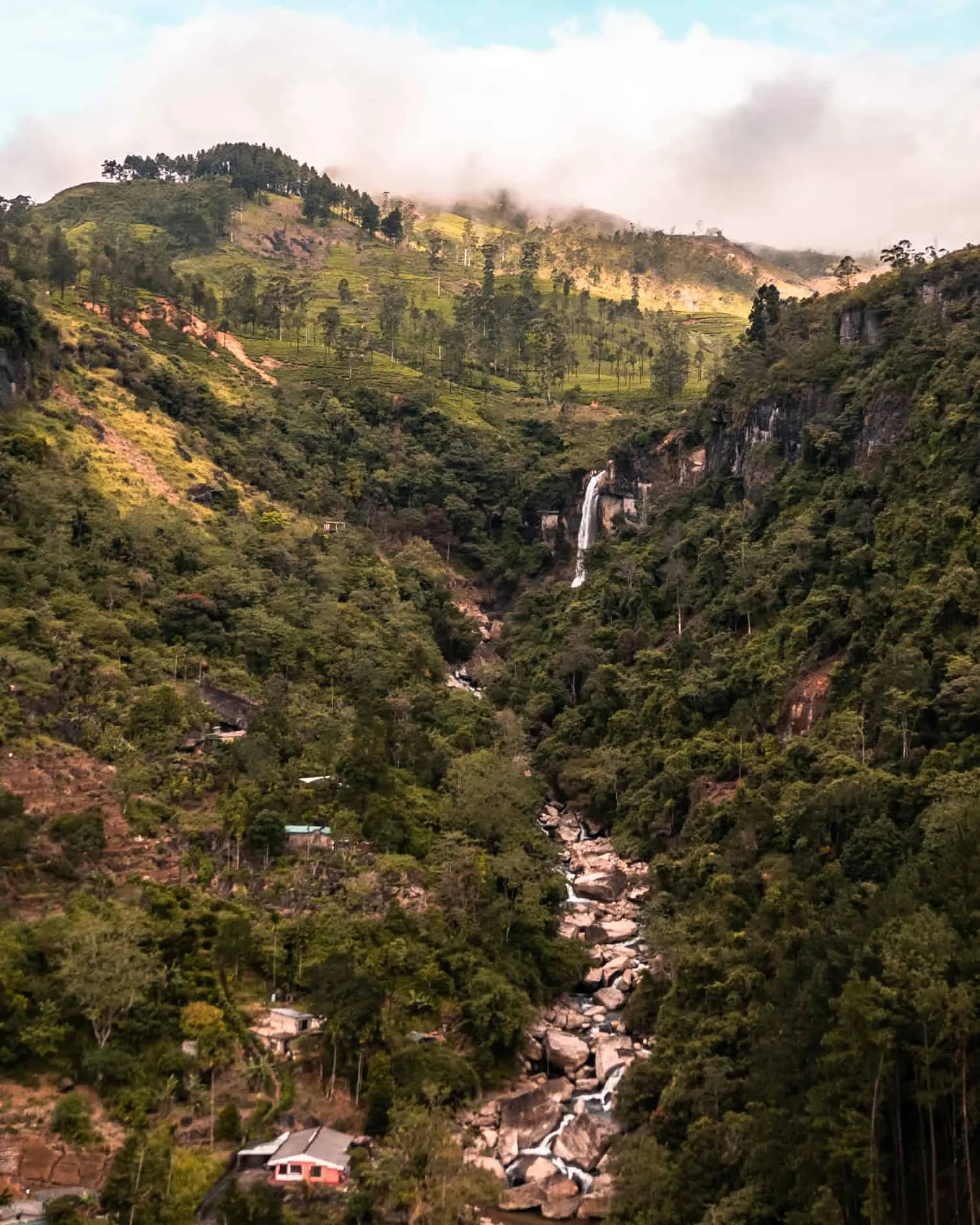 Lush valley with cascading waterfall.