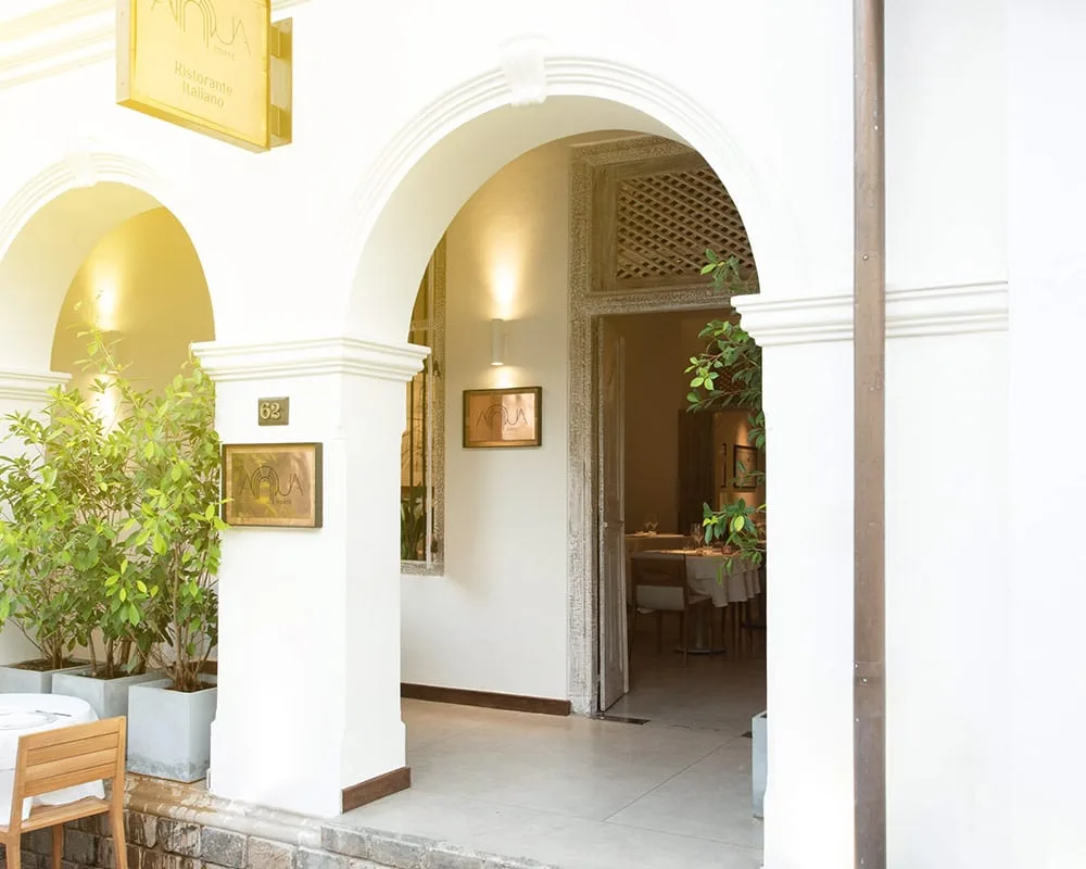 Elegant restaurant entrance with greenery.