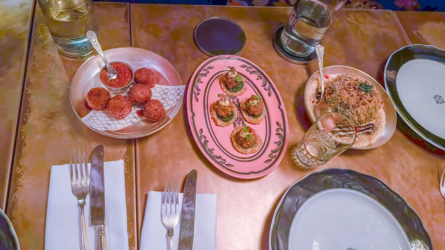 Overhead view of a table set with plates of appetisers, glasses and cutlery in a restaurant