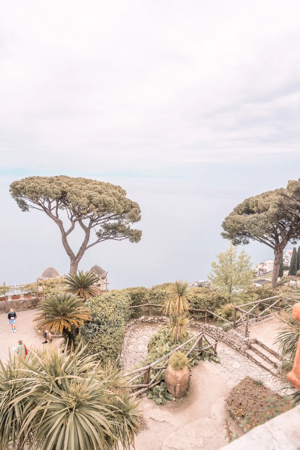 Clifftop Mediterranean garden with umbrella pines, stone paths and sea views stretching to the horizon.