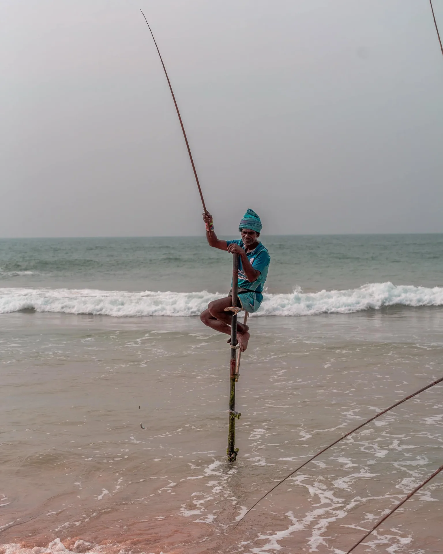 Fisherman balancing on a pole.