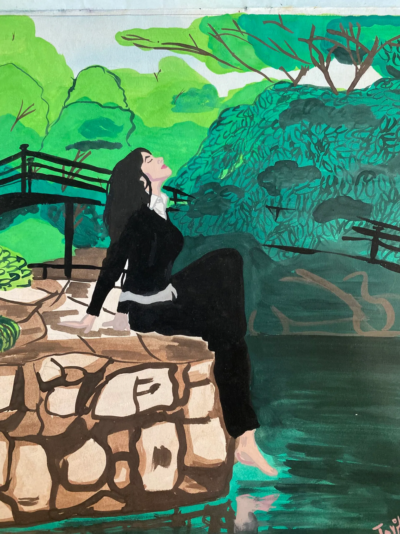 Woman in a black dress sits on a stone ledge dipping her toes into a green pond with a wooden bridge and lush trees behind her.